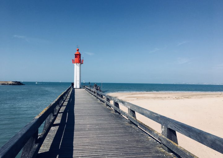 wooden footbridge leading to lighthouse by the sea