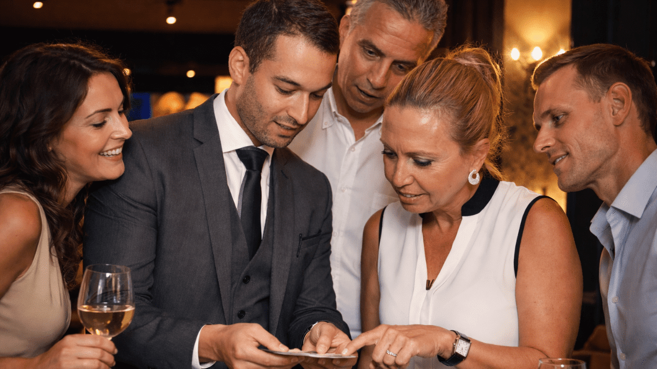 vinz magicien faisant un tour de carte devant un public d'hommes et de femmes